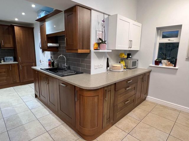 Peninsula kitchen with dark wood units, before