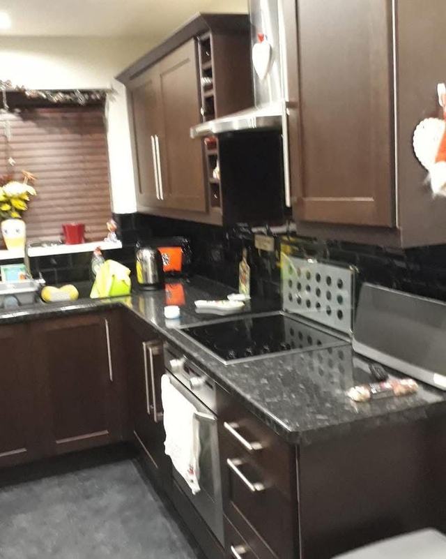 Dark brown kitchen with a black worktop, before