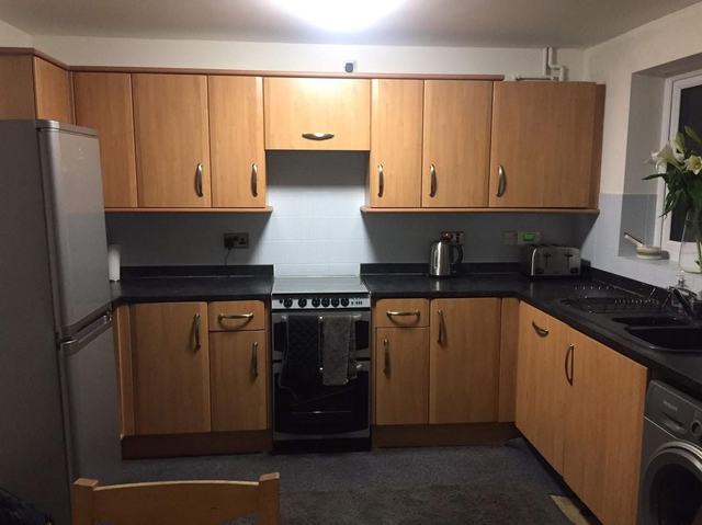 Kitchen with orange pine units, before