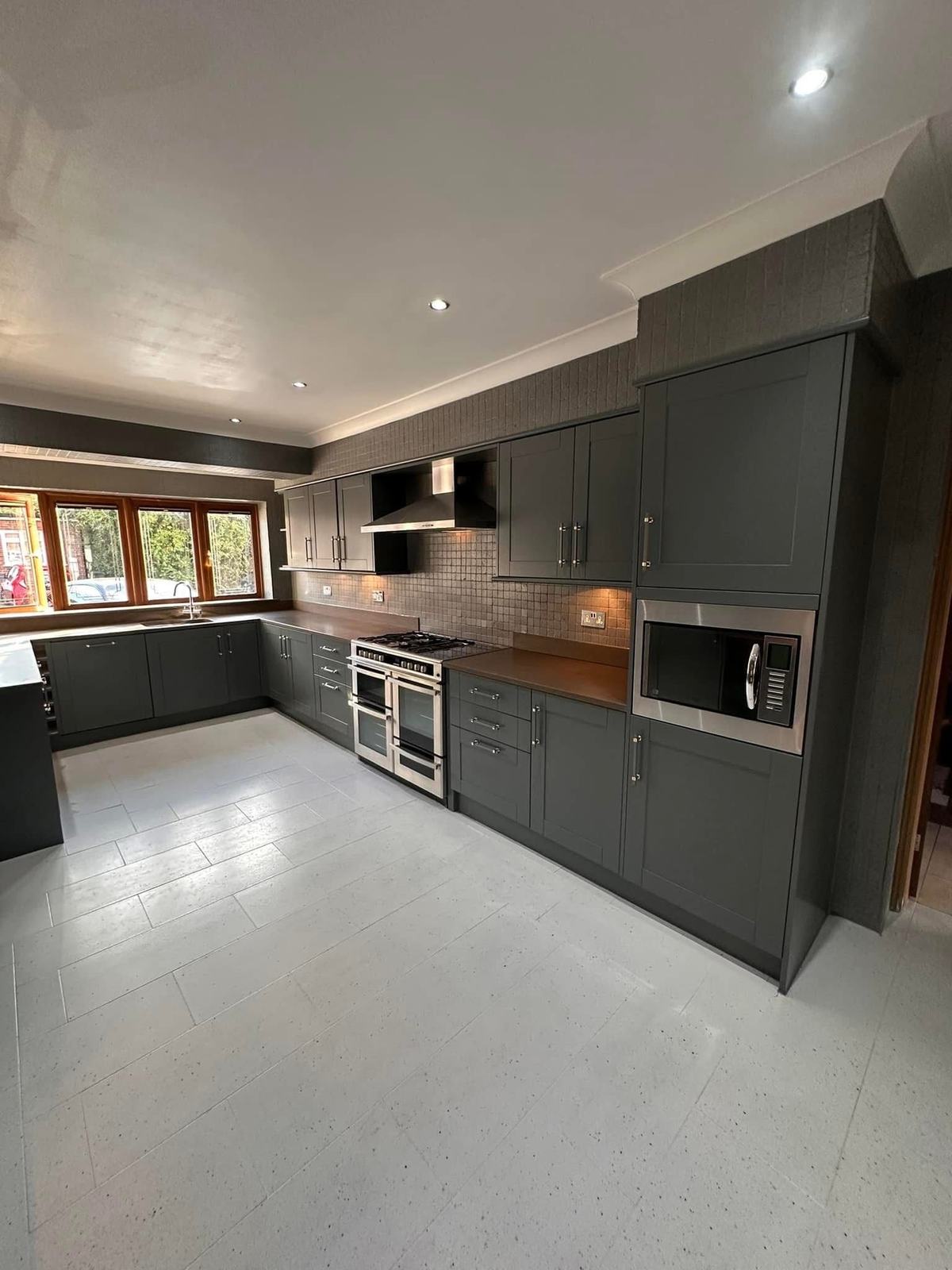 Kitchen units hand painted dark grey with a light floor