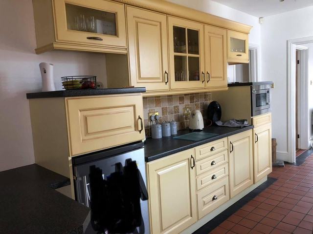 Cream kitchen with a black worktop, before