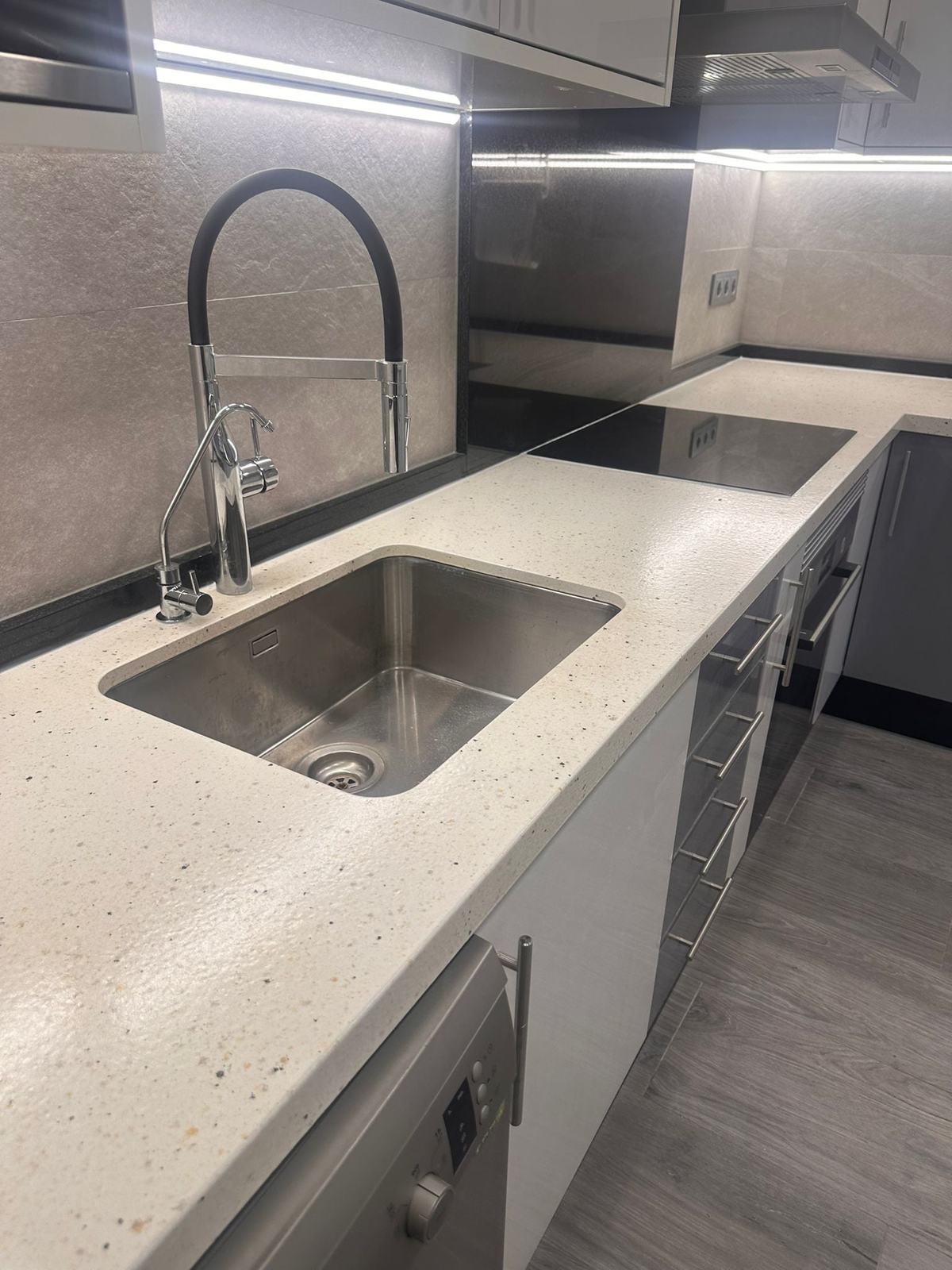Kitchen worktop with a white Spray Granite finish and a stainless sink